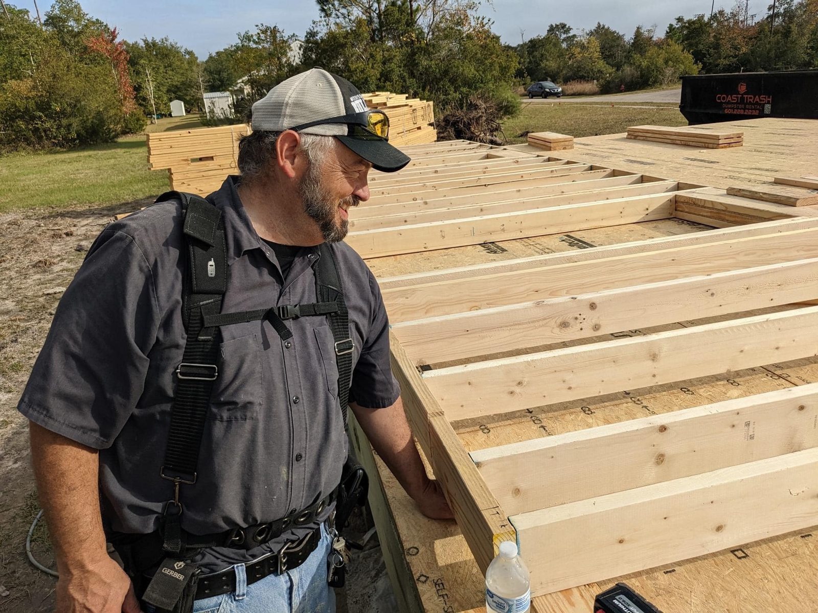 Glenn Newell in a gray work shirt at an actual construction framing jobsite